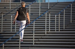 Older woman climbing concrete stairs