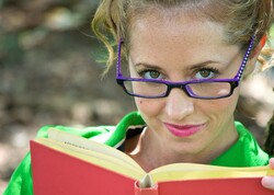 A woman with trendy glasses and a book.