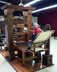 Peter Small demonstrating the use of the Gutenberg press at the International Printing Museum.