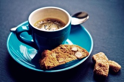 Cup of coffee on a saucer with biscuits and a spoon