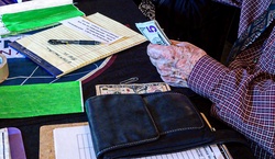 Senior handling cash at a registration table