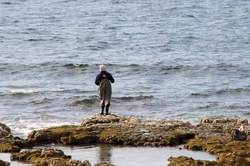 Winter fisherman by stormy sea