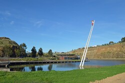 Sculpture of a man on a ladder in a lake