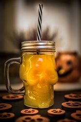 Orange juice in a skull shaped glass for Halloween party