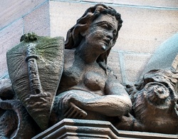 Sculpture of a woman with a shield on the corner of a historic building in Belfast, Northern Ireland