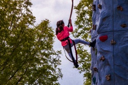 Young girl scales a mock rock mountain