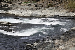 River water dipping in and around rocks in the river bed