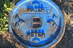 Photograph of a metal cover to a subterranean water meter