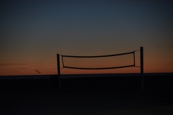 Sunset on the beach. Volleyball net silhouette