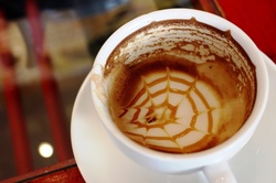 An empty coffee cup with the froth art pattern still in the bottom of the cup