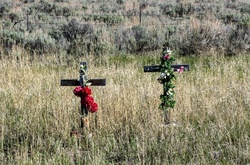 Roadside Memorial Cross: Two floral covered crosses usually signifying where someone died on the highway