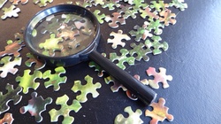 Jigsaw puzzle and a magnifying glass