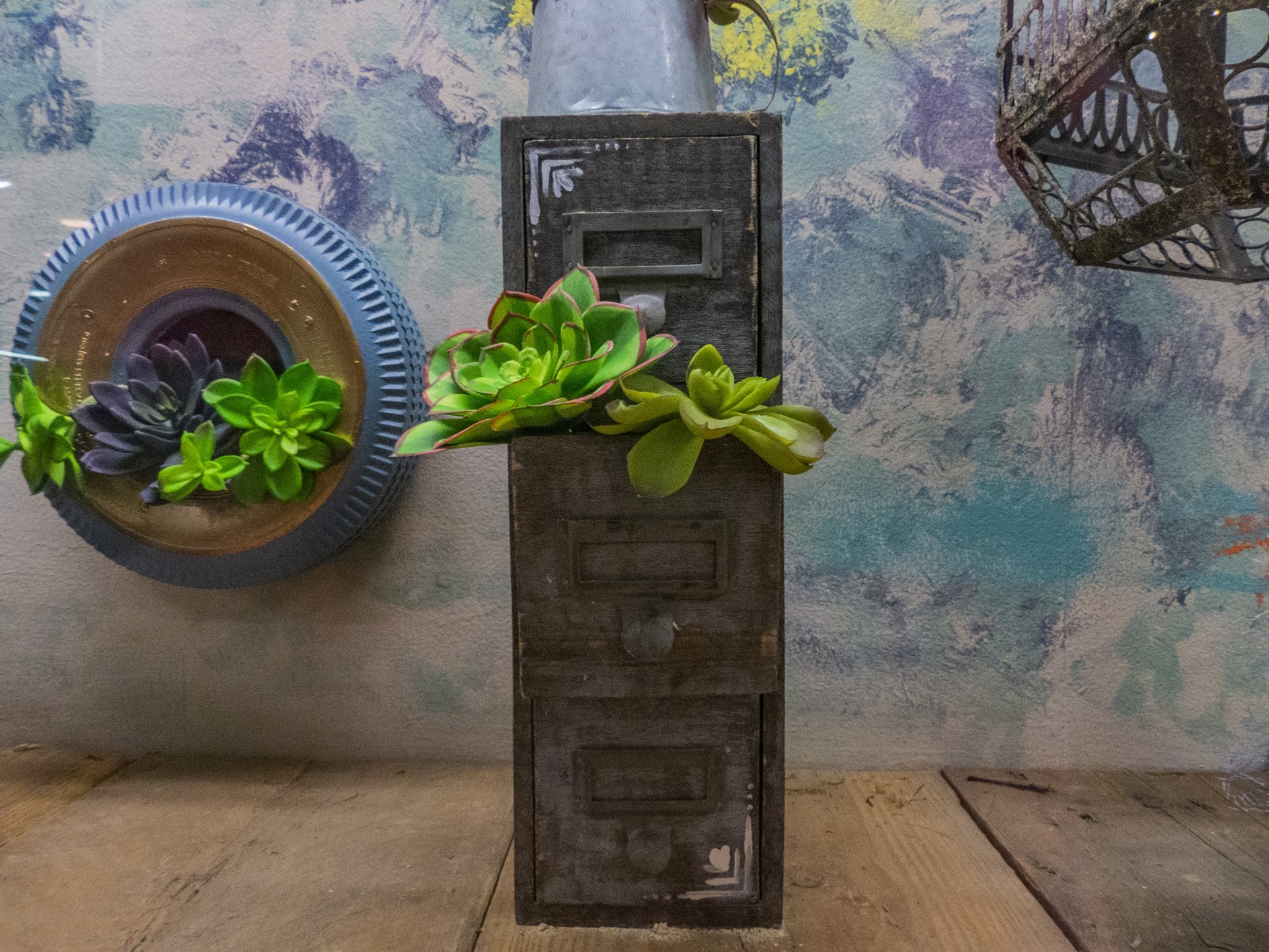 Wall decoration with a small file cabinet a plant growing from one drawer