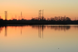 Hydro wires reflecting in still water at dusk