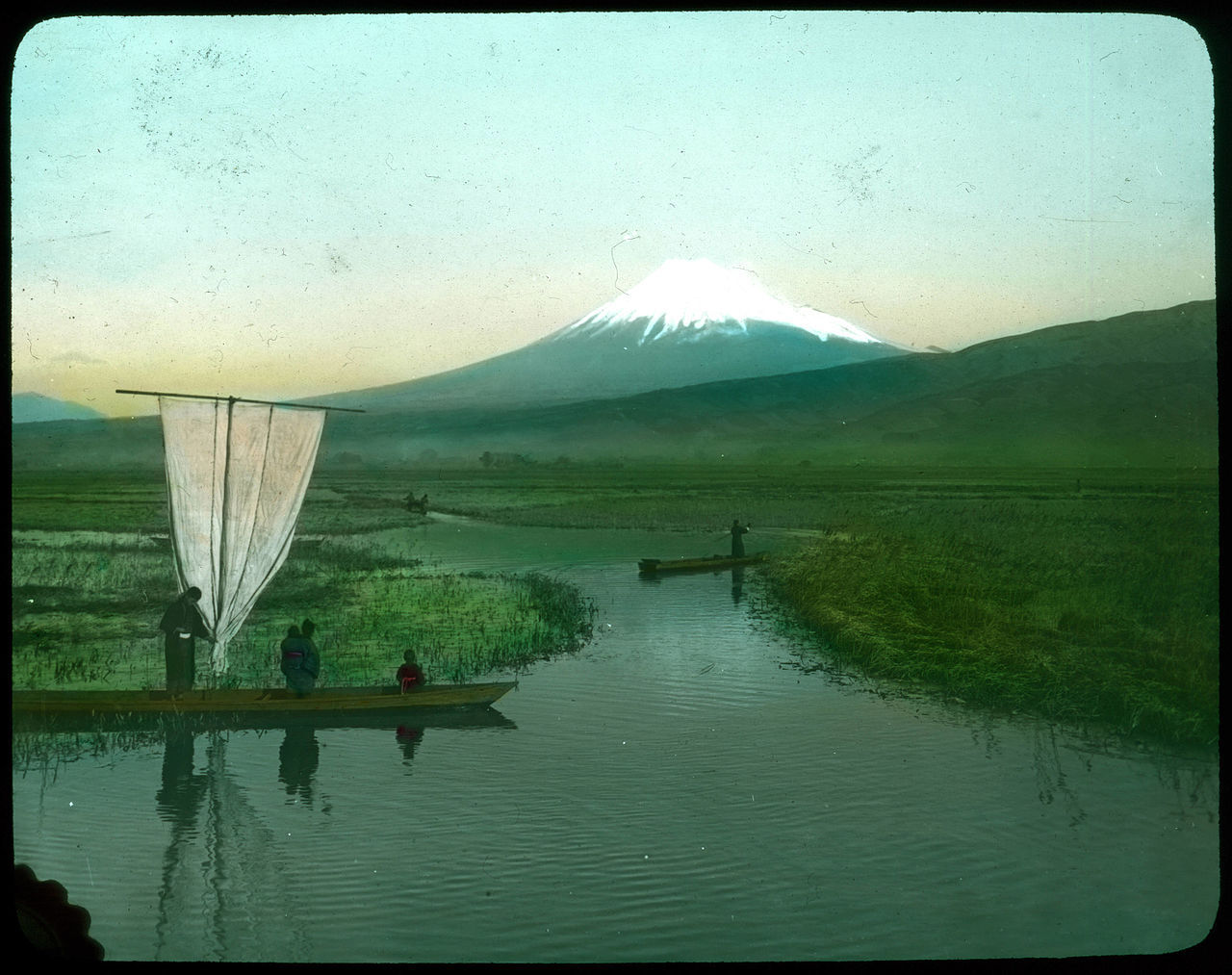 People in boats on waterways through rice fields
