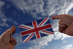 Hands holding face mask with flag of England