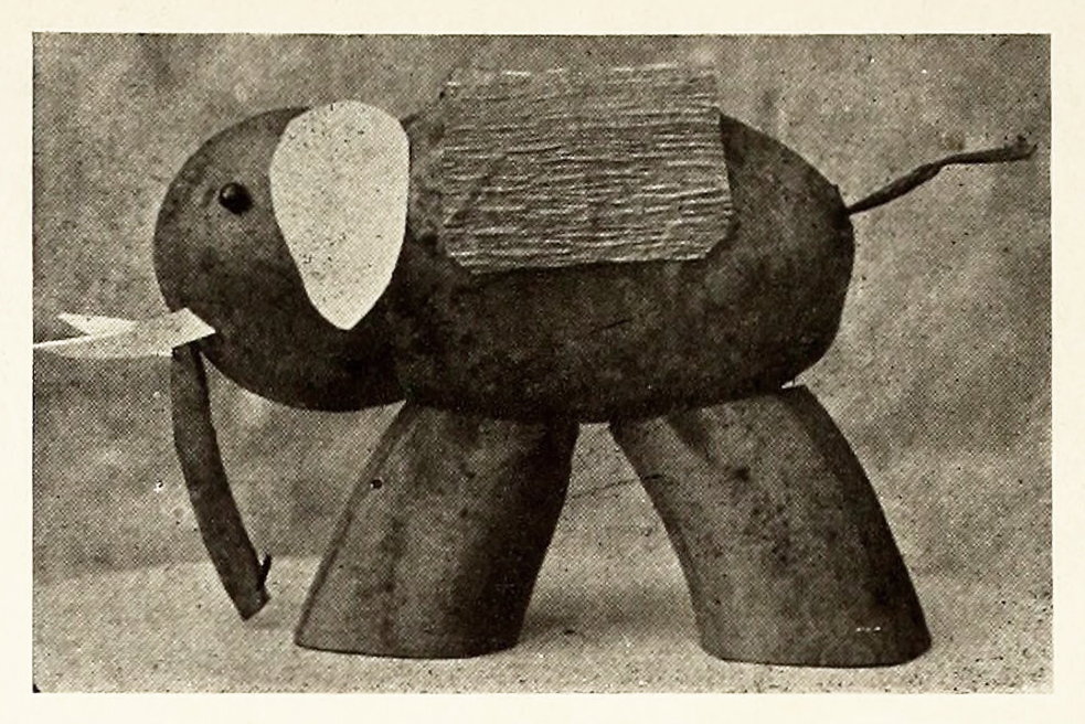 The elephant is made from a big pear and a small apple skewered together and mounted on two pieces of banana.