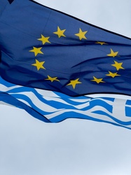 Flags of the European Union and Greece against sky