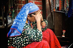 Mexican woman in traditional garb sits in despair on the streets on Mexico City, Mexico.